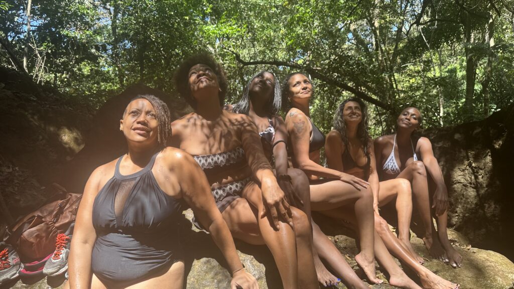 Group of black women friends gathering at a Verde Malakita waterfall in Costa Rica